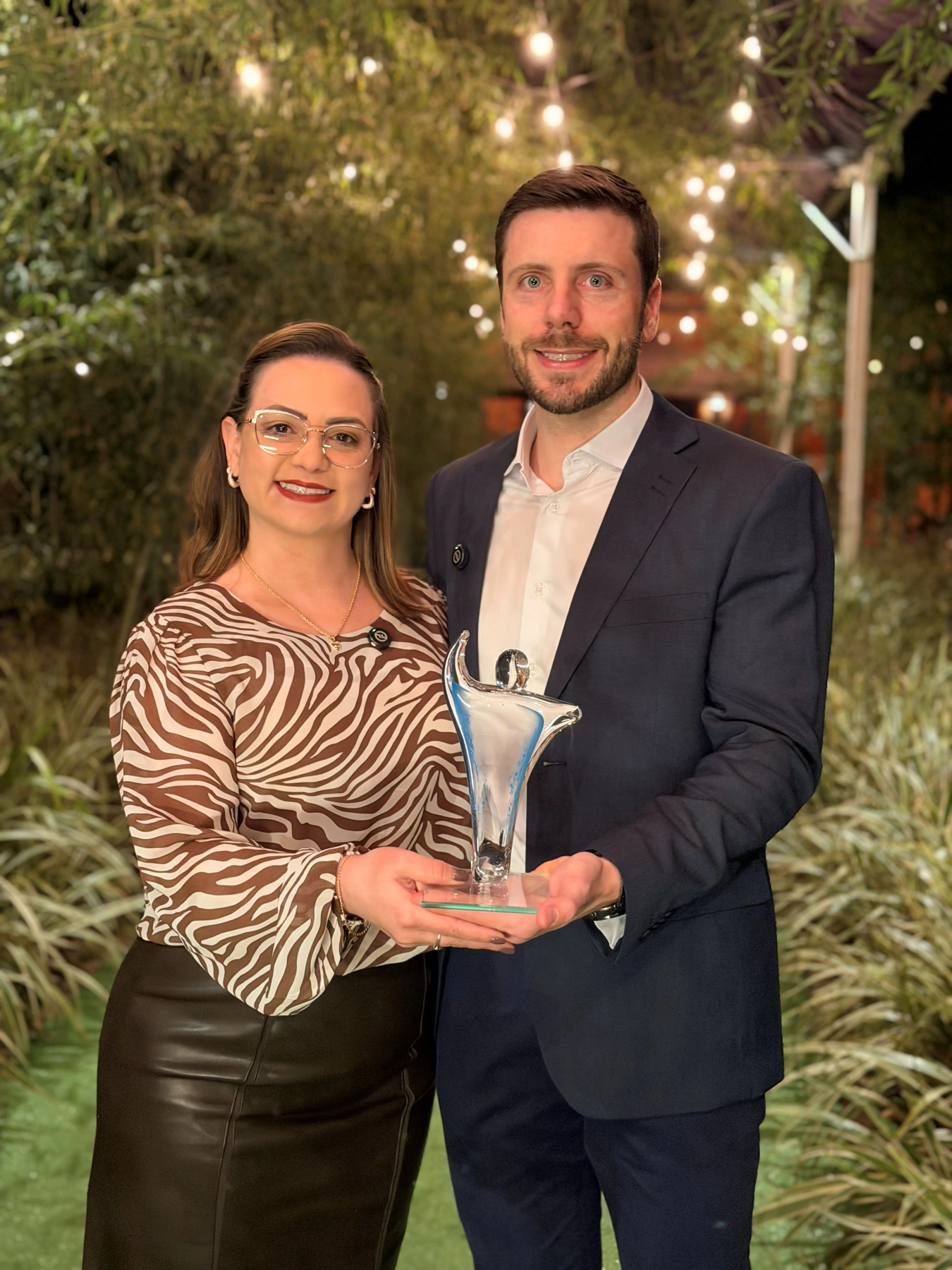 Maitê e Joel na premiação da Podhium Pesquisas, com o troféu recebido pela ContaPro